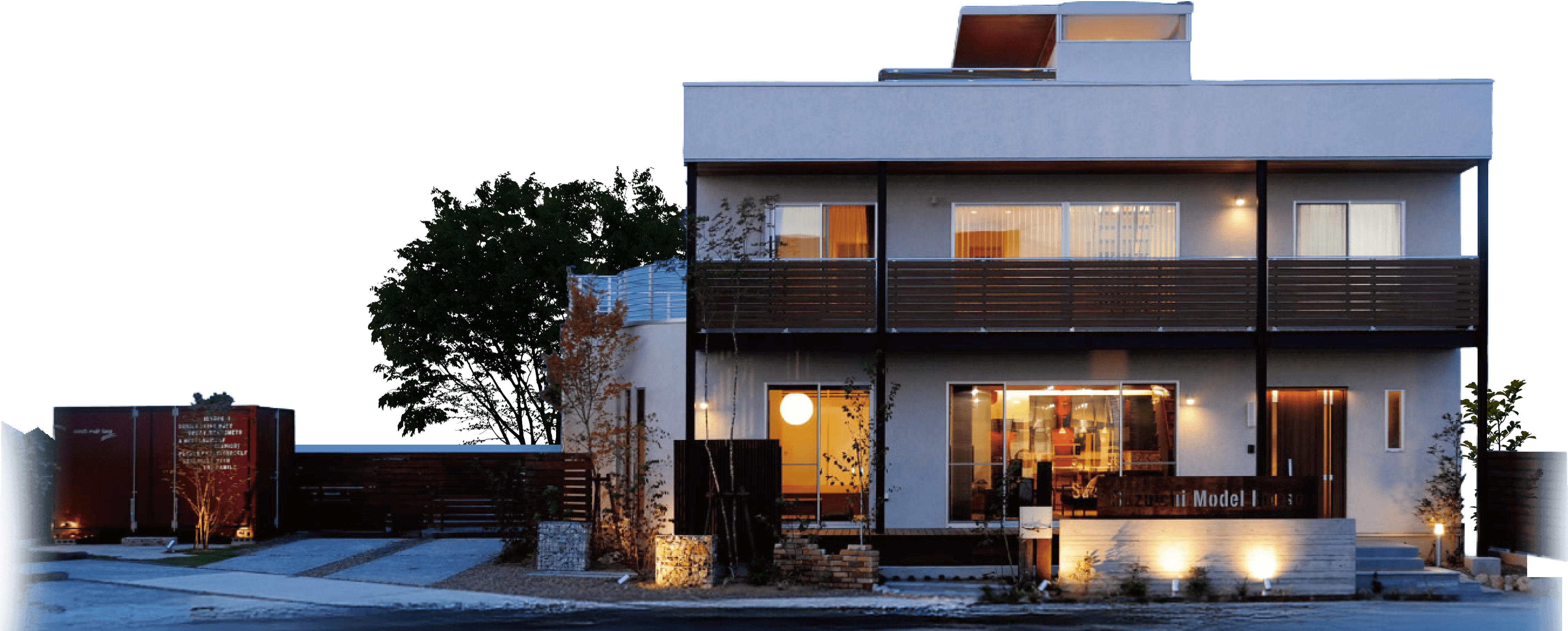 夕景の中でライトアップされた、二階建てモデルハウス外観の様子